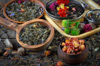 Eski bir arka planda kaşıkta kuru çay yaprakları.