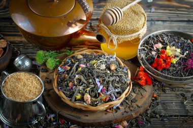 Eski bir arka planda kaşıkta kuru çay yaprakları.