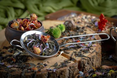 Eski bir arka planda kaşıkta kuru çay yaprakları.