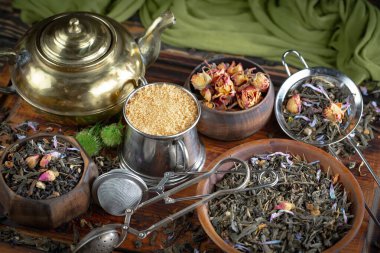 Eski bir arka planda kaşıkta kuru çay yaprakları.