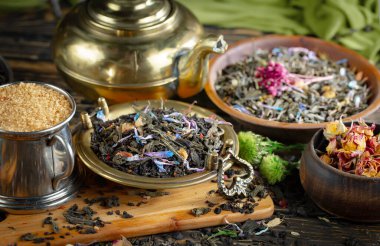 Eski bir arka planda kaşıkta kuru çay yaprakları.