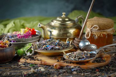 Eski bir arka planda kaşıkta kuru çay yaprakları.