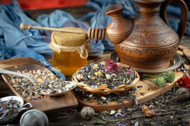 Eski bir arka planda kaşıkta kuru çay yaprakları.