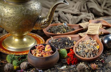 Eski bir arka planda kaşıkta kuru çay yaprakları.