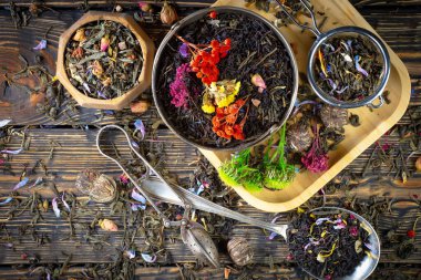 Eski bir arka planda kaşıkta kuru çay yaprakları.