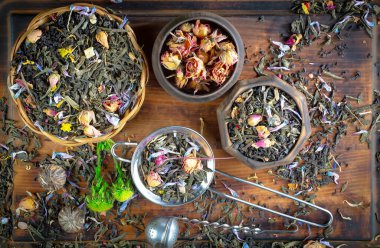 Eski bir arka planda kaşıkta kuru çay yaprakları.