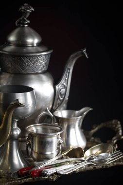 Eski bir arkaplanda gümüş eşyalar.