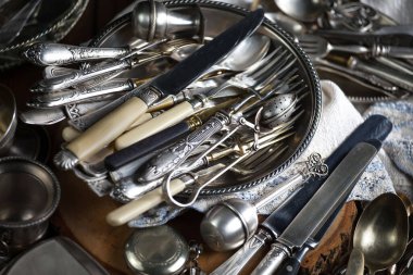 Eski bir arkaplanda gümüş eşyalar.