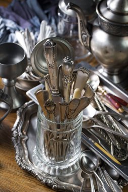 Eski bir arkaplanda gümüş eşyalar.