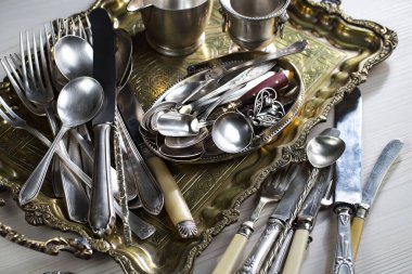 Eski bir arkaplanda gümüş eşyalar.