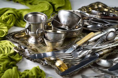 Eski bir arkaplanda gümüş eşyalar.