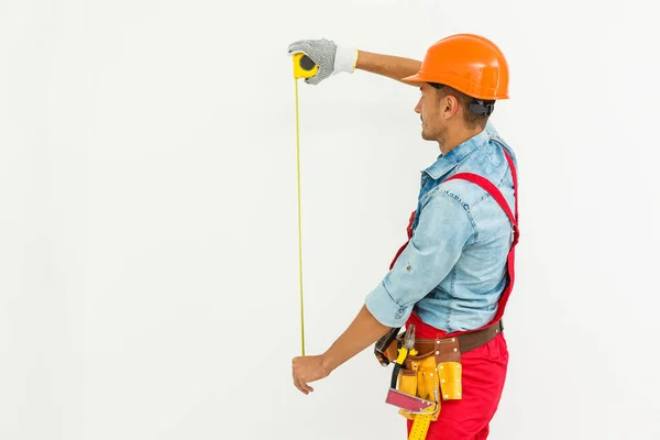 stock image The builder in a helmet with a tape measure.