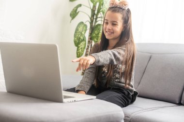 Genç kız öğrenci evde ders çalışıyor, notlar alıyor. Ergen öğrenci uzaklığı laptopta öğreniyor, ödev yapıyor, video dersi izliyor. Uzaktan eğitim kavramı.