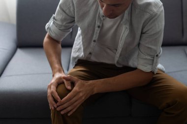 Adam dizini yaraladı, elini tuttu.