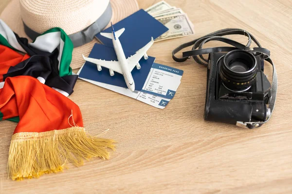 passport, tickets, toy plane, camera, UAE flag.