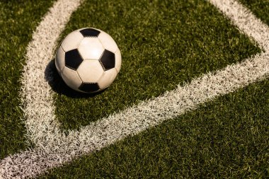 Yeşil çimlerde ve stadyum arka planında beyaz ve siyah futbol topu. Spor bahisleri