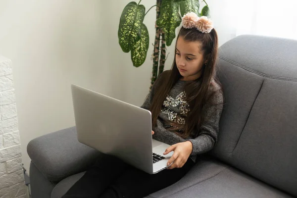 Kafkasyalı Genç Kız Elinde Bilgisayarla Evdeki Gri Koltukta Oturuyor — Stok fotoğraf