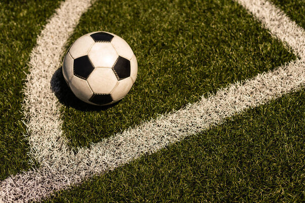 белый и черный футбольный мяч на зеленом фоне травы и стадиона. идея ставок на спорт