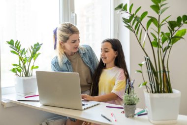 Güzel anne ve çocuk dizüstü bilgisayar ekranında app eğitim programı kullanarak mutfakta zaman geçirmek bakar, karikatürler seçin, çocuk pc kullanımını öğretmek, internet siber uzay konsepti ne kızı izlerken kontrol