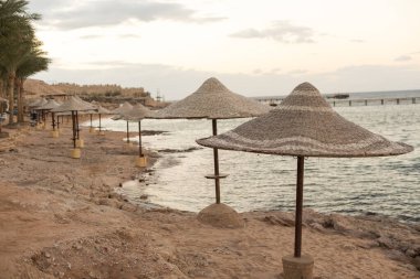 Mavi gökyüzü ile hasır plaj şemsiye