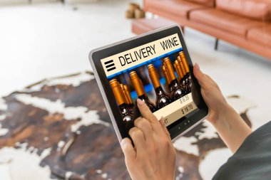 Person holding tablet and buying wine online