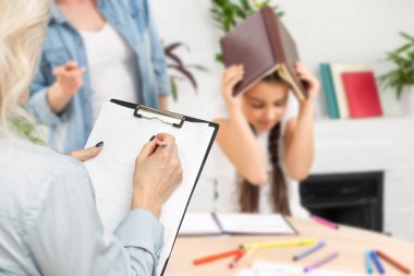 Konuşmak anlamanın anahtarıdır. Ebeveyn ve çocuk psikoloğu birlikte görüyor. Danışman terapist ve anne okul haberlerini paylaşan, hikaye anlatan ve soruları cevaplayan reşit olmayan kızları dinliyor.