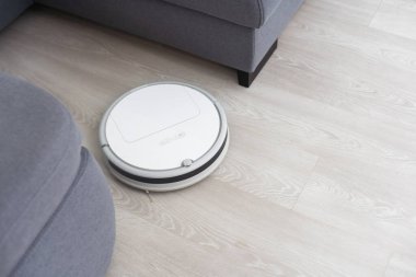 Robotlar temizlik için oturma odasındaki halı temizleyicilerini süpürür