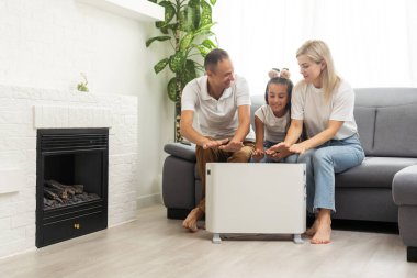 Aile eller elektrikli ısıtıcı üzerinde ısınmak.