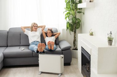 Family warming up near home heater at winter cold time. The symbolic image of the heating season at home