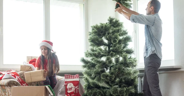 幸せな父と彼の小さな娘は家でクリスマスツリーを飾る — ストック写真