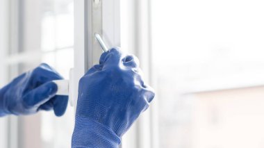 Bir çerçeve eve plastik montajı, inşaatçı bir tornavidayla pencere çerçevesini yamaçlara vidalar. yakın plan