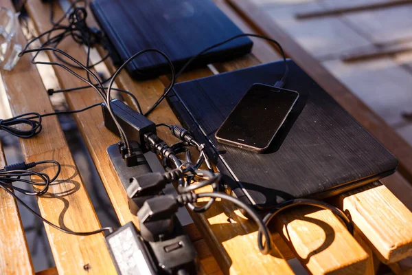 Stock image laptops on a wooden table in the park.