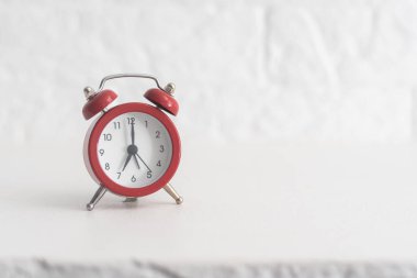 Kırmızı alarm saati, beyaz arkaplanda dört izole edilmiş, yakın plan.