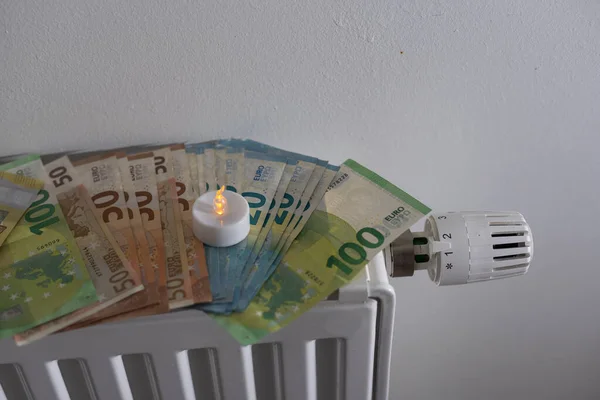 stock image euro banknotes on the radiator and a candle.