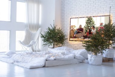 Yeni yıl arifesi. Yumuşak bej sırtı ve dekoratif yastıkları olan Noel ağacı yatağı. Mutlu Noel kavramları