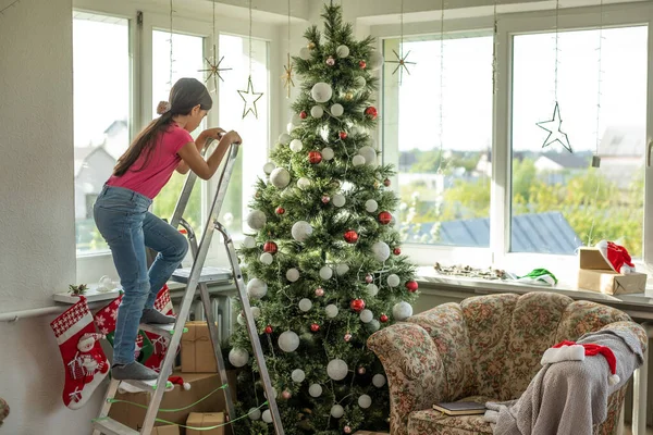 Kislány Egy Létrán Díszíti Karácsonyfa — Stock Fotó