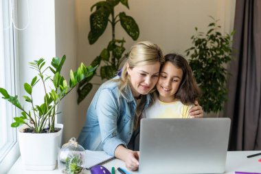 Güzel anne ve çocuk dizüstü bilgisayar ekranında app eğitim programı kullanarak mutfakta zaman geçirmek bakar, karikatürler seçin, çocuk pc kullanımını öğretmek, internet siber uzay konsepti ne kızı izlerken kontrol