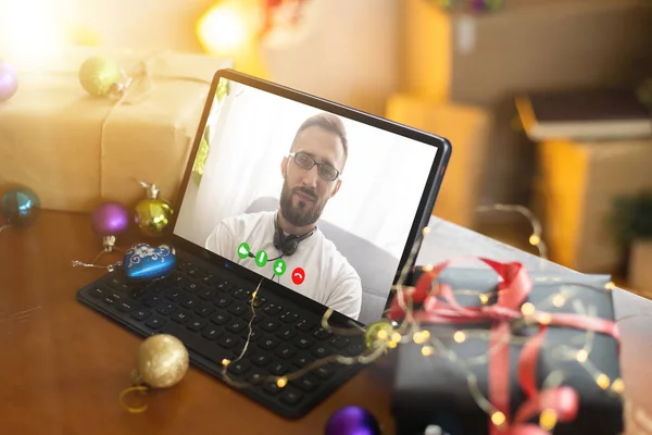 Virtual Christmas tree meeting team teleworking. Family video call remote conference. Laptop webcam screen view. Team meet working from their home offices.