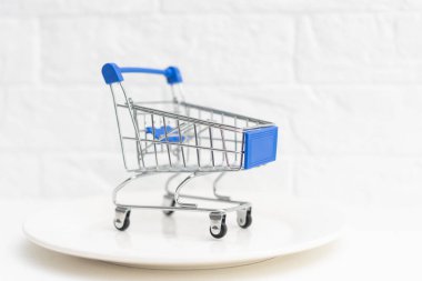 Beyaz tabakta alışveriş arabası..