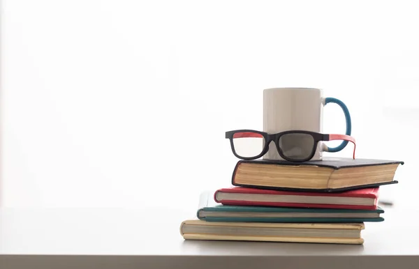 ホット コーヒーや紅茶 ココア チョコレート カップ本と本棚の背景本文コピー スペースを持つ眼鏡 本やメガネ ライブラリ内のテーブルの上にカップの山 — ストック写真