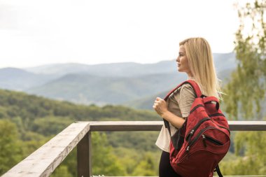 a woman rests after a hike in the mountains.