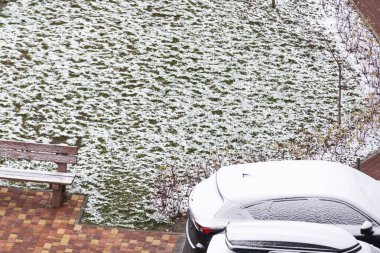 Kasvetli bir sonbahar günü ve şehir meydanındaki ilk kar.