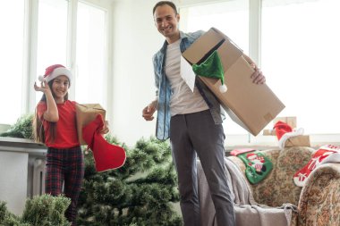 Baba ve kızı yapay bir Noel ağacı kuruyor..