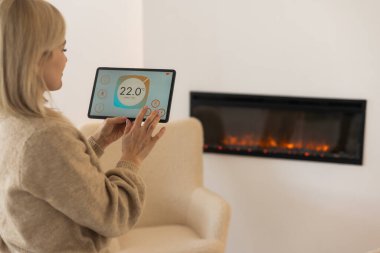 Bir tablet ile akıllı ev perde tutan bir kadın.