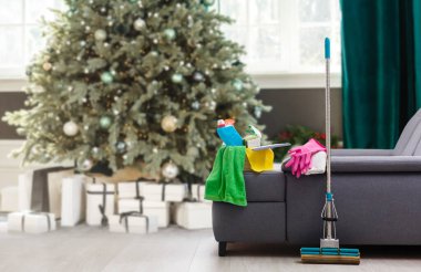 Noel 'den önce temizlik. Çok renkli temizlik malzemeleri. Süngerler, paçavralar ve arka planda süslü püslü spreyler..