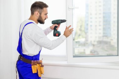 servis elemanı tornavidayla pencere kuruyor.