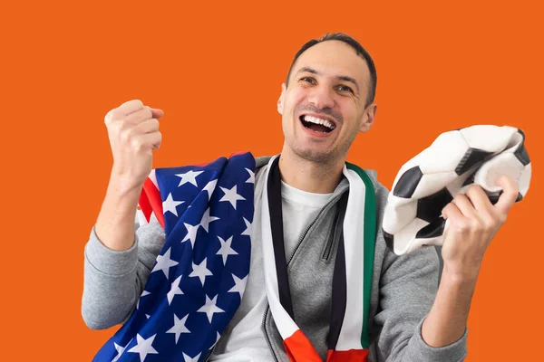 stock image male football fan with a crumpled ball and with the flag of the UAE and the USA.