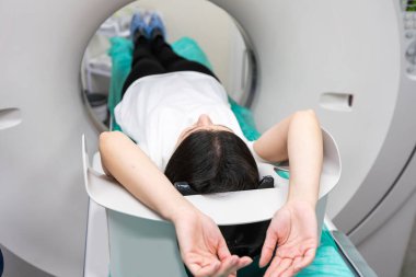 Radyolog, bilgisayarlı tomografi odasında bir kadın hasta ile birlikte..