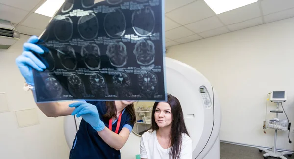 Beautiful female radiologist looking at the MRI scan images.