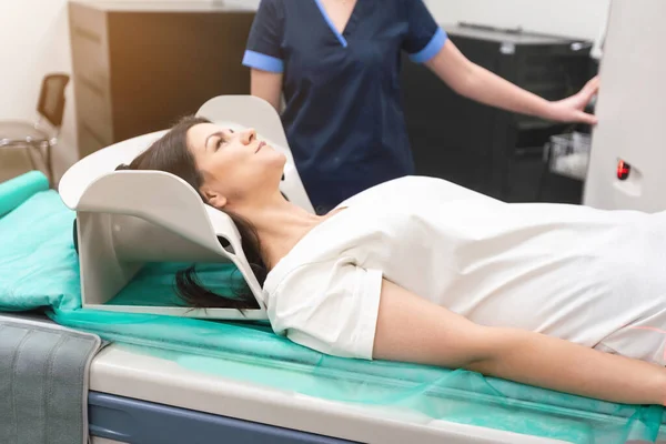 一个女人躺在断层扫描台上 一名妇女正在一家现代化医院接受计算机轴线断层扫描 — 图库照片